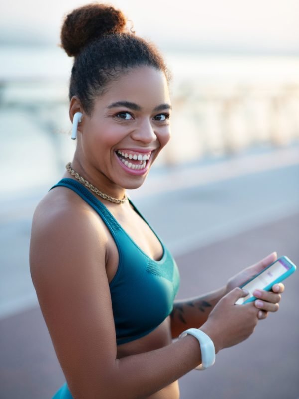 Woman feeling happy. Dark-eyed woman wearing smart watch feeling happy after morning run